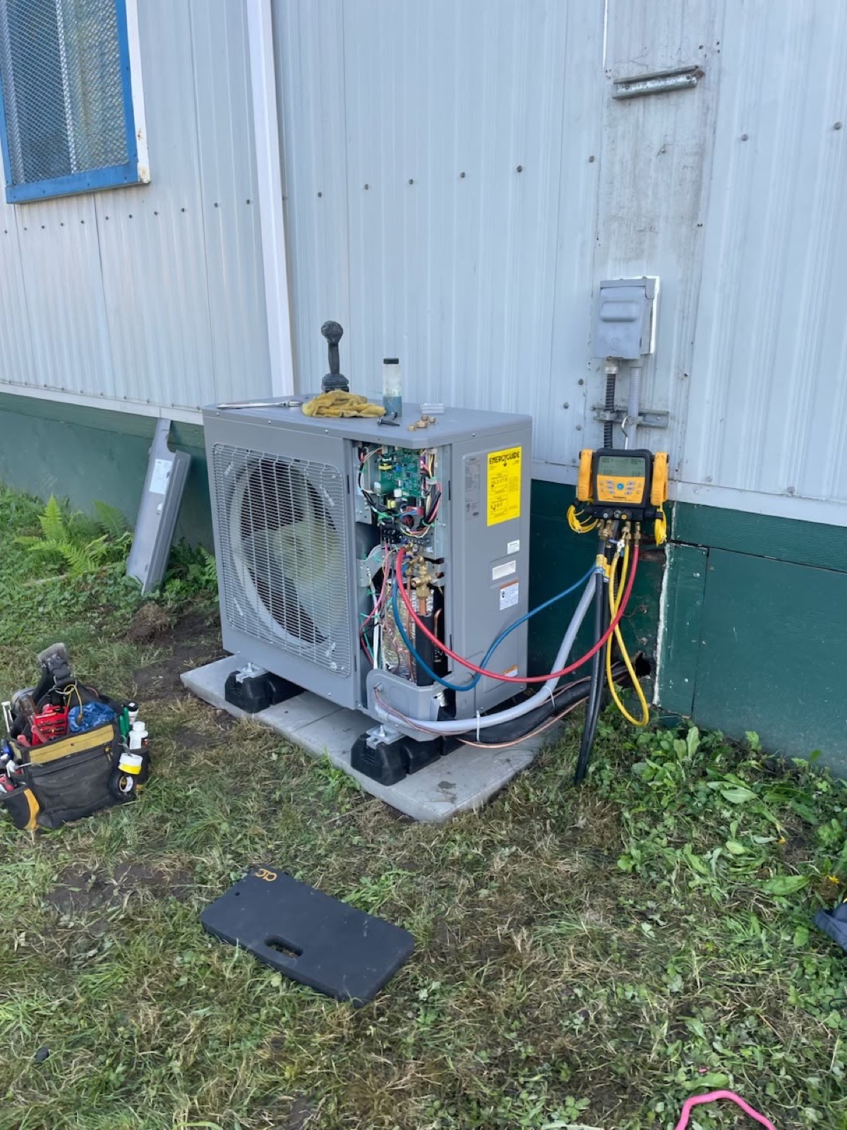 Outdoor heat pump connected to HVAC gauges for system testing